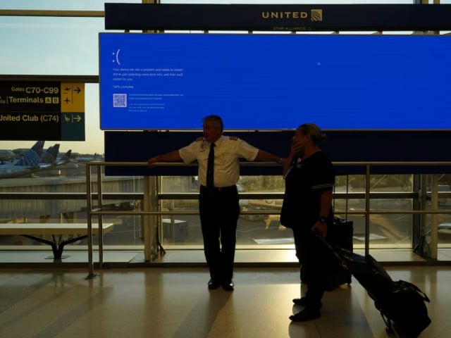 united airlines employees wait by a departures monitor displaying a blue error screen also known as the blue screen of death inside terminal c in newark international airport after united airlines and other airlines grounded flights due to a worldwide tech outage photo reuter